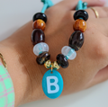 Maak je viervoeter extra schattig met de handgemaakte Blueberry Brown hondenketting! De ketting heeft een lief turquoise koord gecombineerd met warme, diepbruine en bronskleurige kralen. 